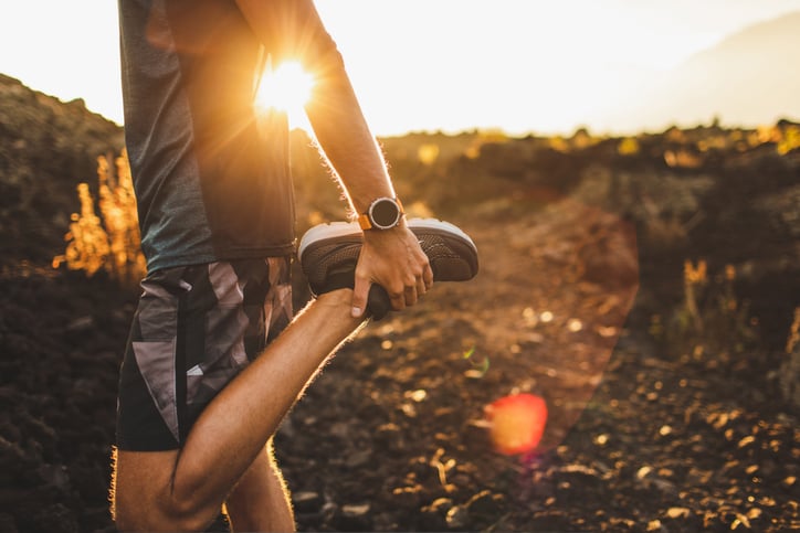 Male runner stretching leg