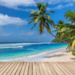 Beach wooden table and coconut palms with party on tropical beach background.